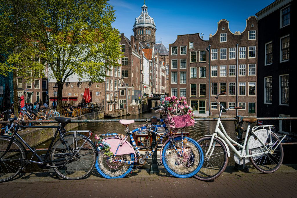 Bike rental Amsterdam: Decorated bike with flowers by an Amsterdam canal