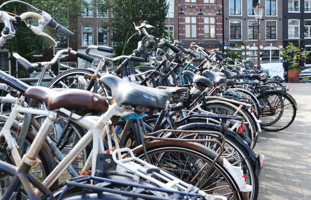 Bike rental Amsterdam: Rows of parked bikes lined up along an Amsterdam canal street