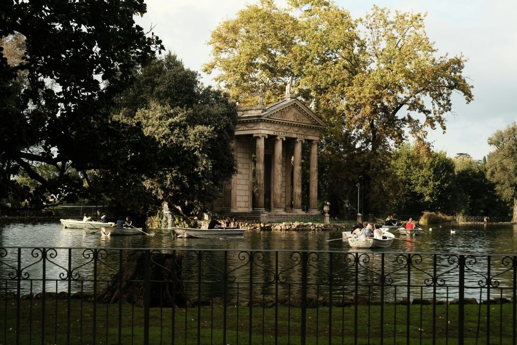 Rom guenstig: Ruderboote auf dem See der Villa Borghese mit dem Tempel des Äskulap im Hintergrund