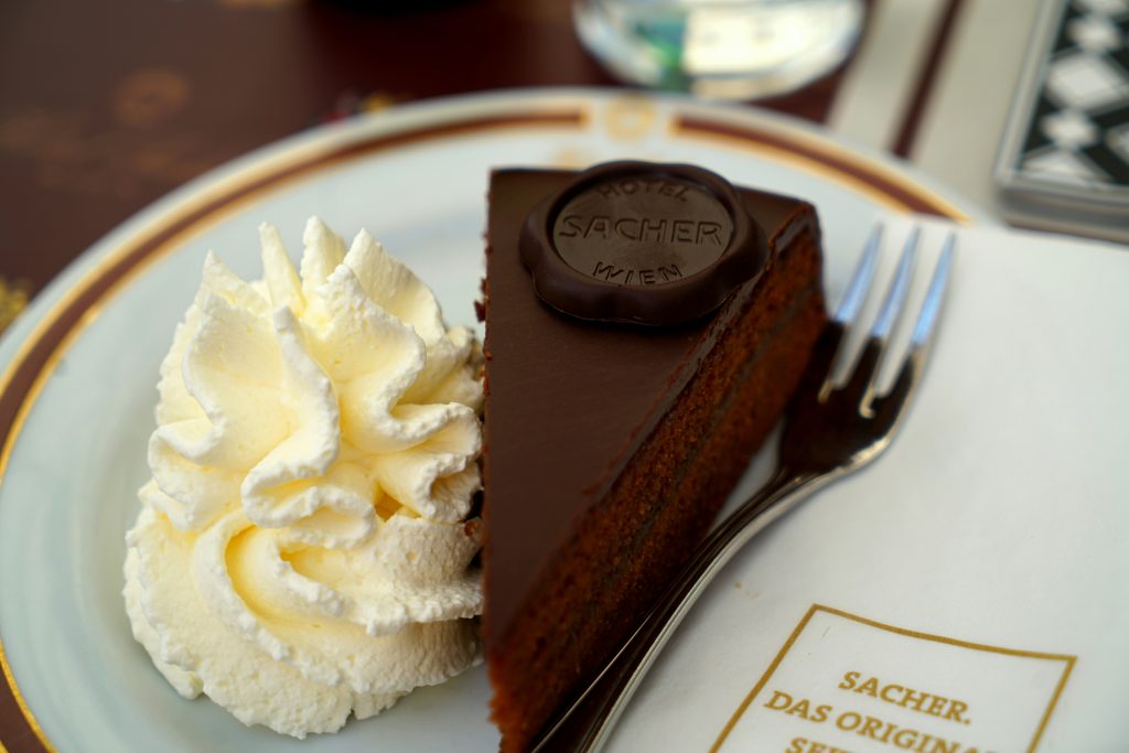 Cosa mangiare a Vienna: fetta di Sachertorte con panna montata