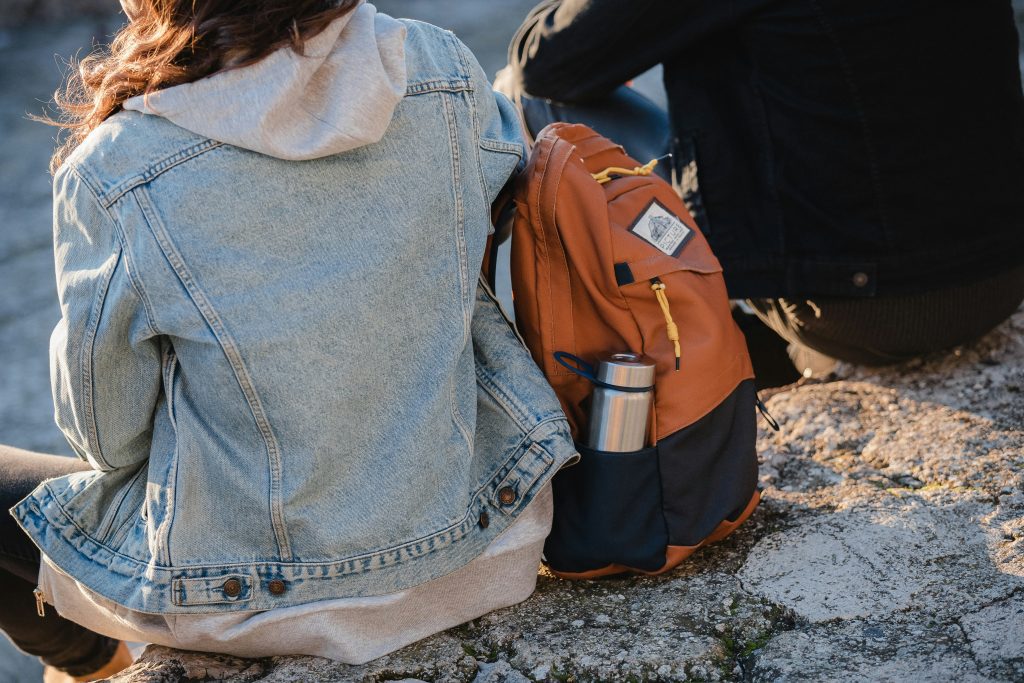 Backpacking France on a budget: Two backpackers resting with a packed backpack in France