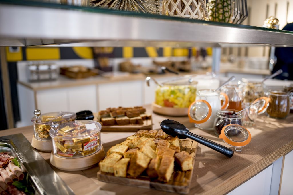 Breakfast buffet with bread, chocolates, jam, and cold cuts