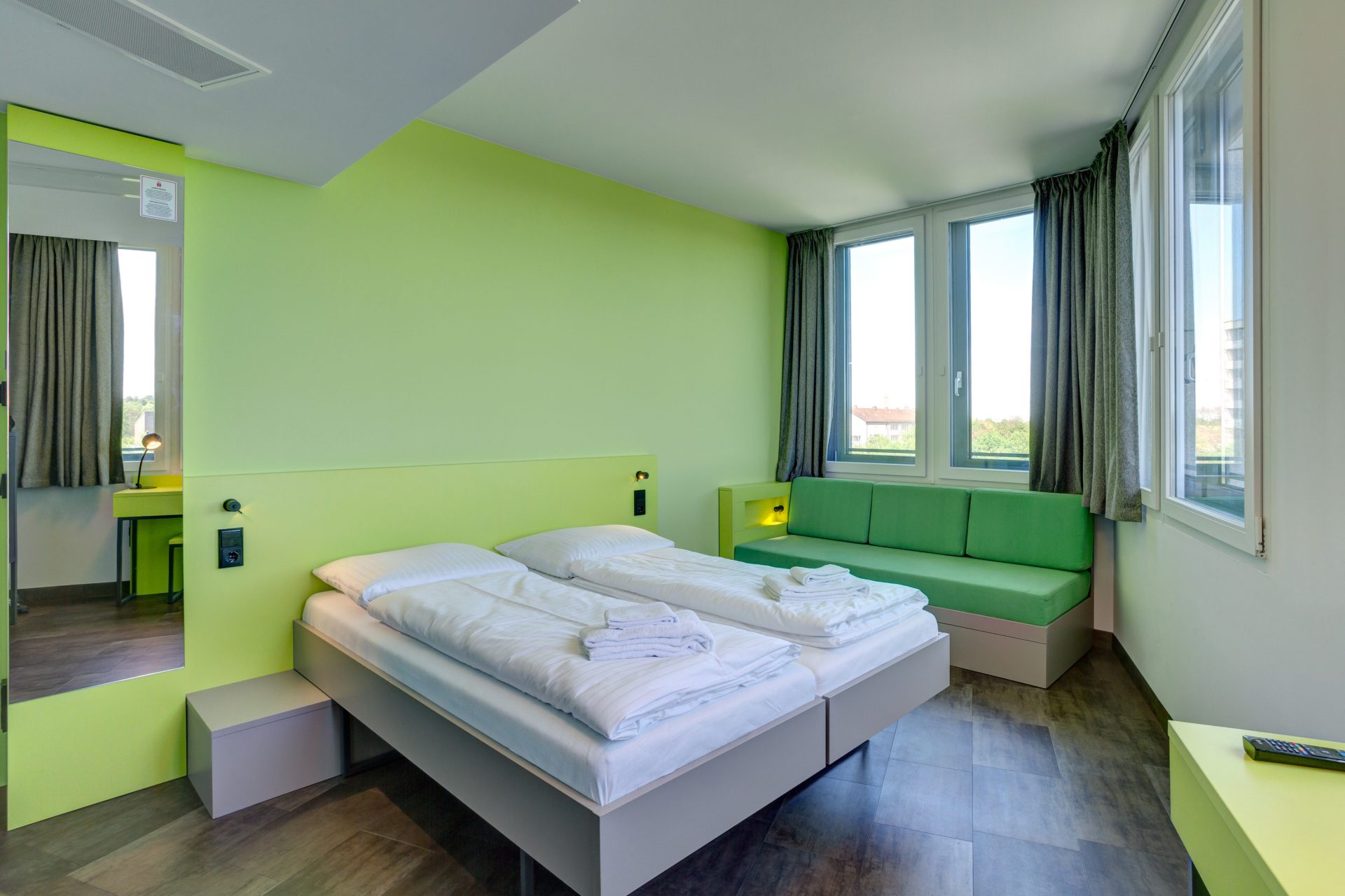Comfy double room with big window at the MEININGER Hotel München Olympiapark