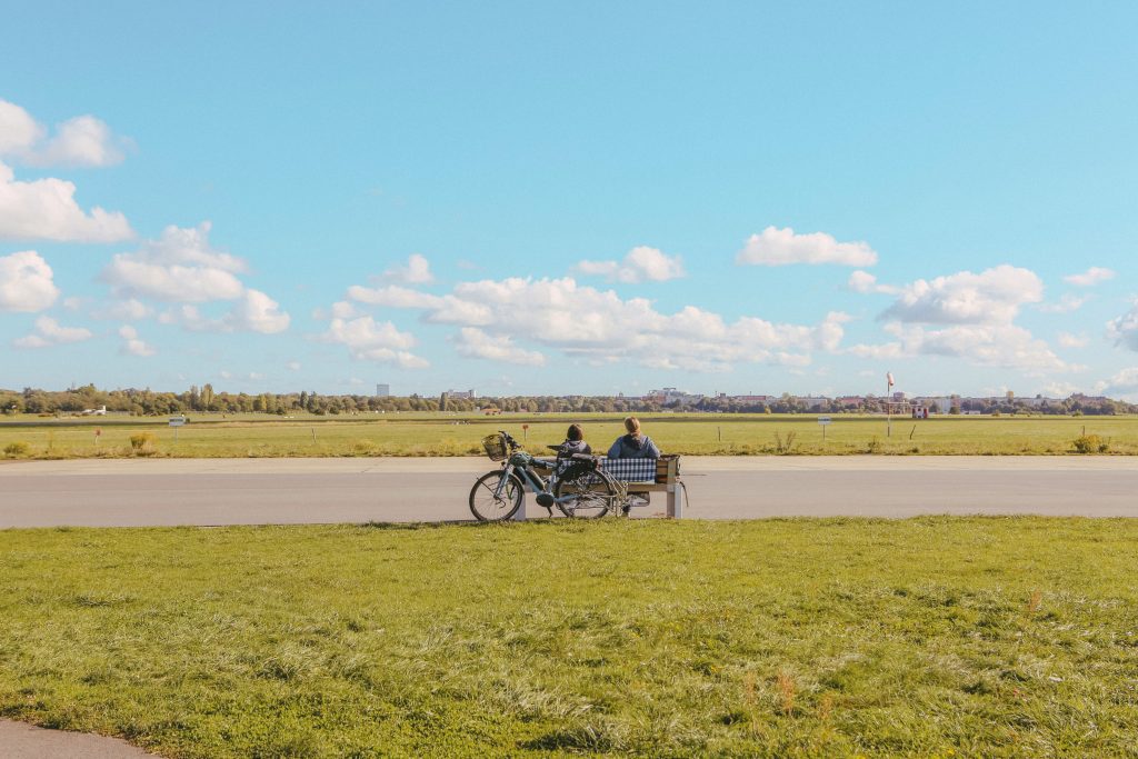 Was du an einem Sonntag in Berlin machen kannst: Ein Paar entspannt mit dem Fahrrad auf der offenen Startbahn des Tempelhofer Felds
