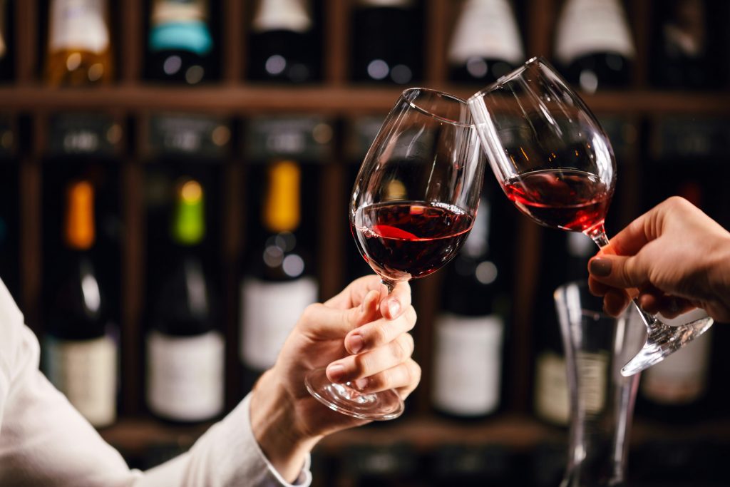 What to eat in Bordeaux: Cheers with two glasses of red Bordeaux wine at a bar