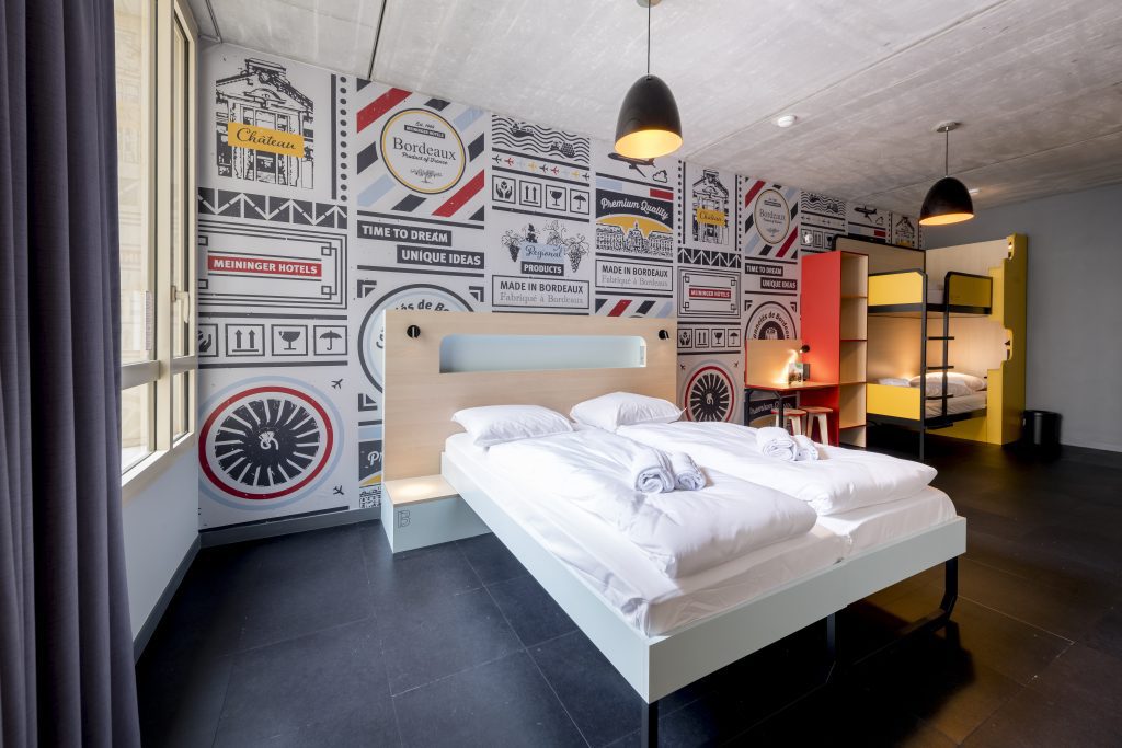 Hotel room with a double bed and bunk beds, Bordeaux-themed wall