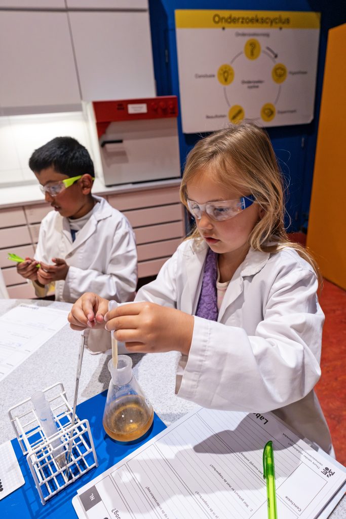 Amsterdam en famille : des enfants jouant avec des béchers en verre et réalisant des expériences scientifiques