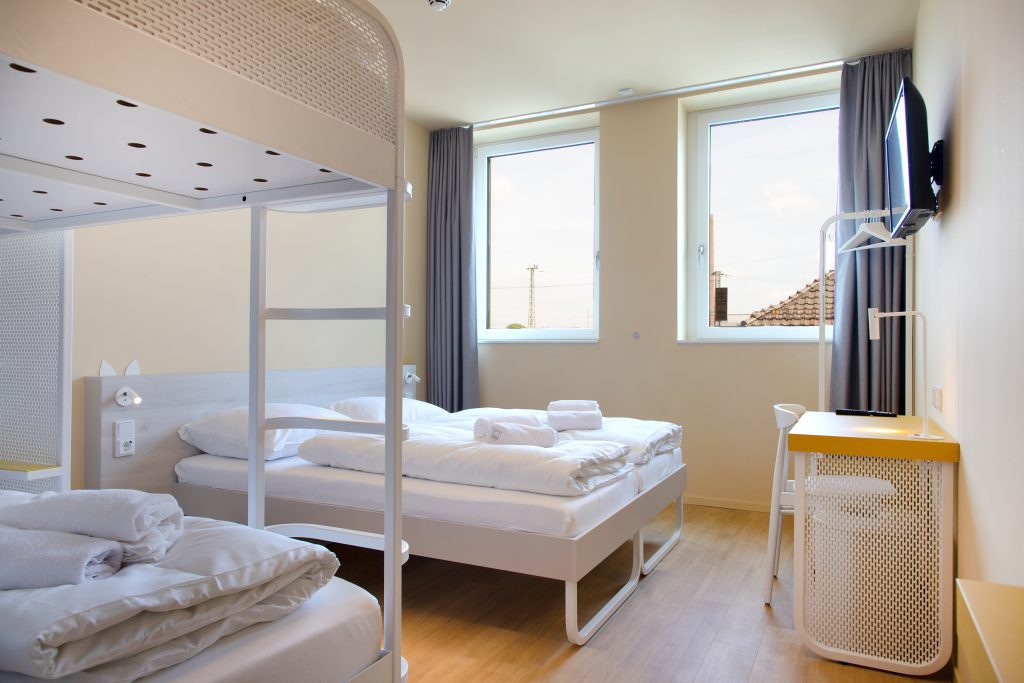 Bunk bed and double bed in a bright MEININGER Hotel Bremen Hauptbahnhof room