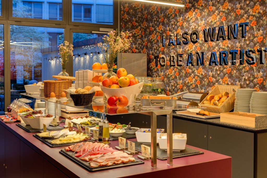 Breakfast buffet with fresh fruit, cheese and cold cuts at MEININGER Hotel Leipzig Hauptbahnhof