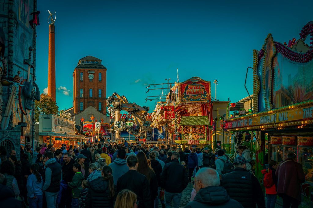 Hidden gems in Germany: Crowds and glowing funfair stalls at Bremen's Freimarkt at dusk