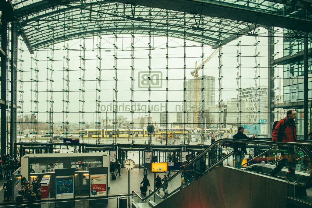 Luggage storage Berlin: Travelers on escalators inside Berlin Hauptbahnhof's glass train station hall