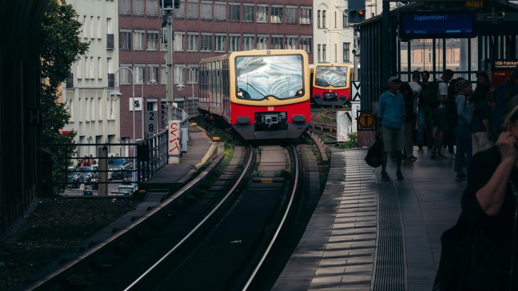 A yellow and red train arriving at a station