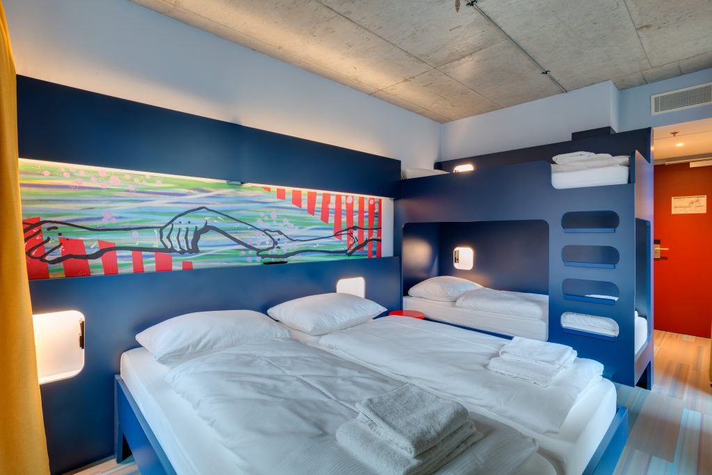 Dortoir partagé avec cadre de lit bleu et décoration murale
