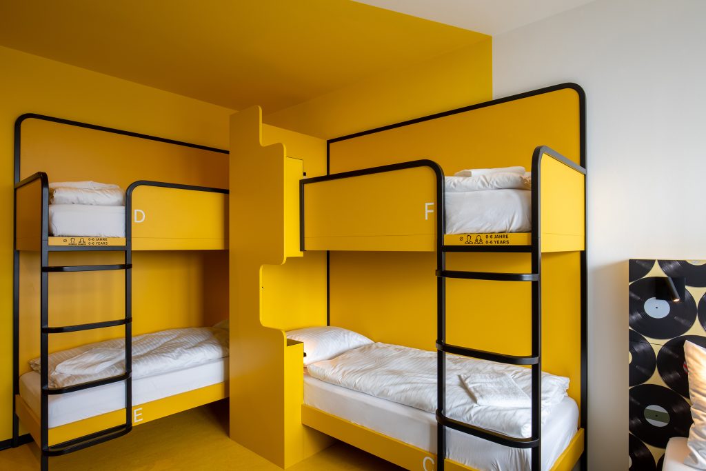 Chambre à plusieurs lits au MEININGER Hotel Dresden Zentrum, idéale pour les amis et les familles qui visitent le Striezelmarkt