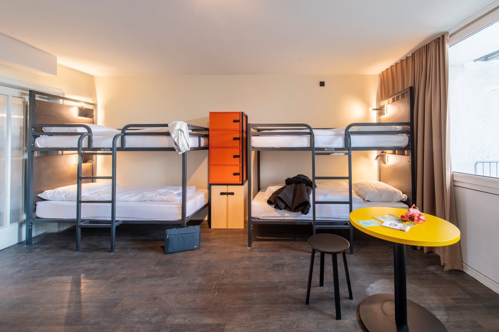 Chambre à plusieurs lits au MEININGER Hotel München Zentrum, idéale pour les groupes qui explorent les marchés de Noël de Munich