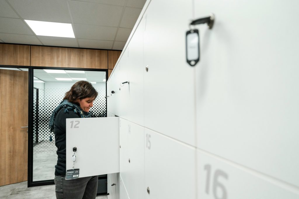Luggage storage Amsterdam: Woman picking up her things from a numbered luggage locker
