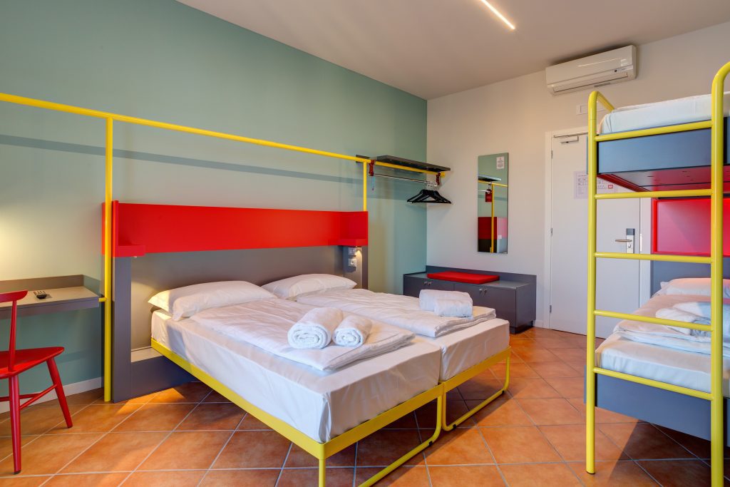 Family room with a double bed, yellow bunk beds and terracotta floor tiles