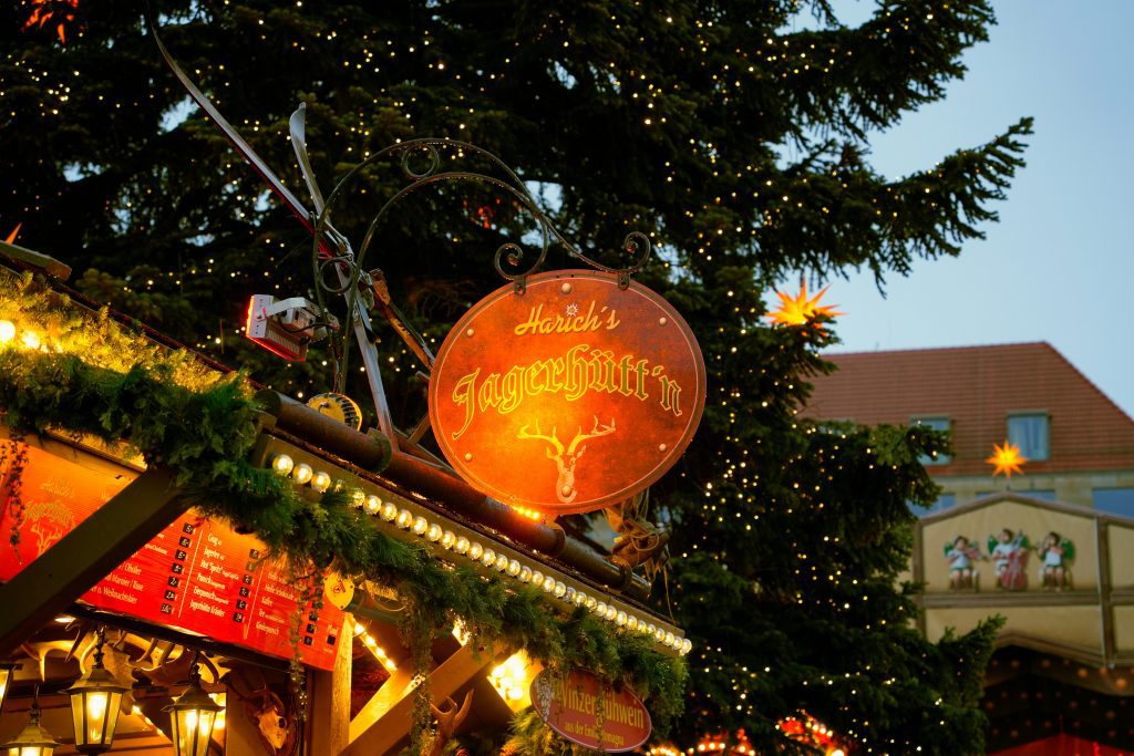 Marché de Noël de Dresde : enseigne de stand illuminée sous un sapin scintillant