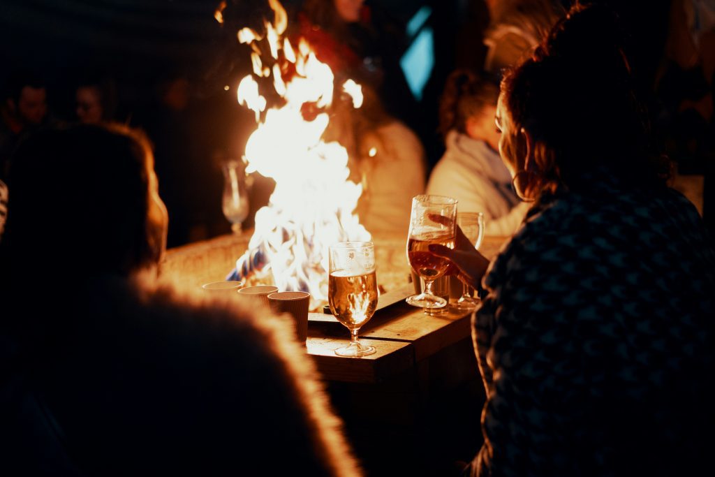 Shadows of people drinking in front of a fire