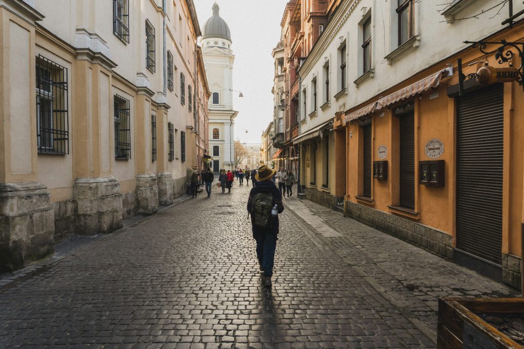 Solo female traveller with a backpack exploring a cobbled old town street