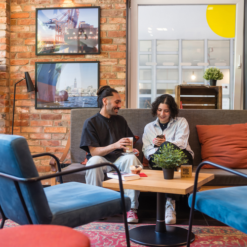 Business travelers collaborating in a modern shared workspace at MEININGER Hotels