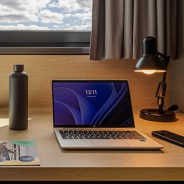 Gros plan d'un voyageur pointant le site web de MEININGER Hotels sur un ordinateur portable.