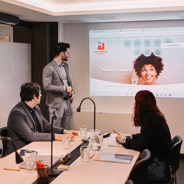 A worker presenting his powerpoint to other two colleagues