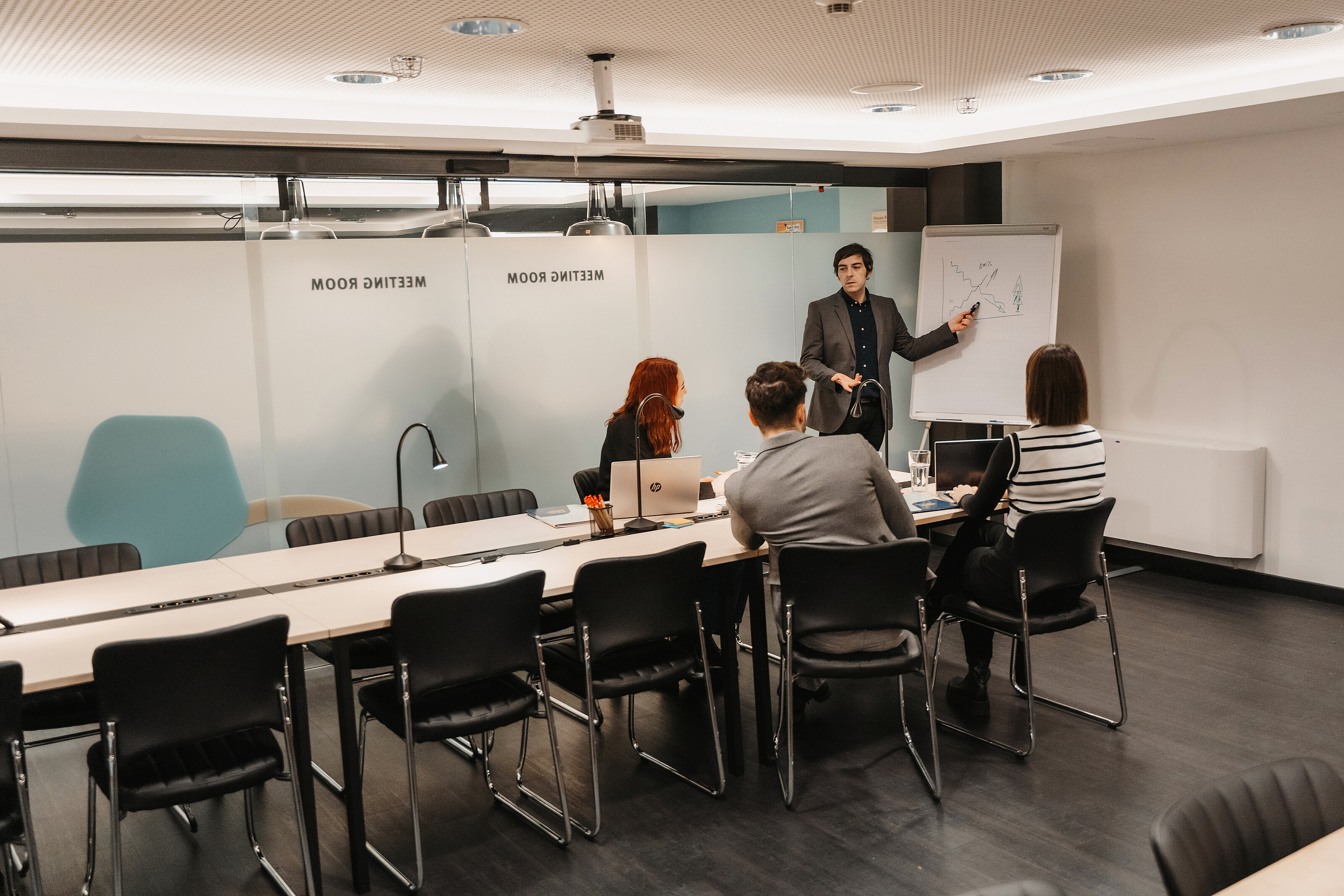 A meeting room with workers following a presentation