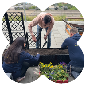Team planting flowers at MEININGER Hotels supporting green spaces