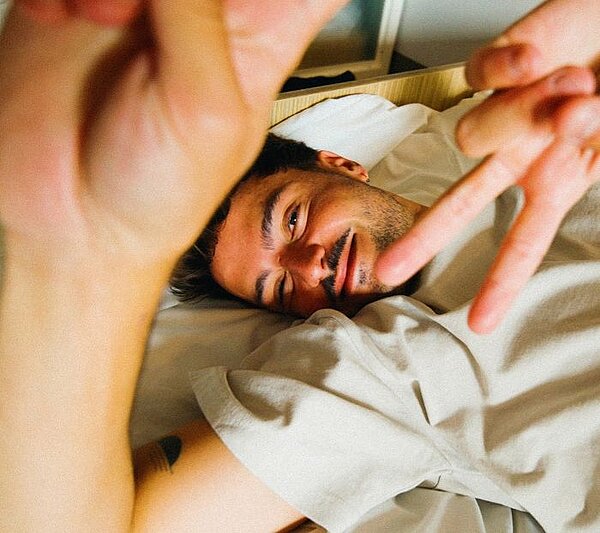 Coppia che gusta il caffè e guarda insieme le tariffe MEININGER Hotels