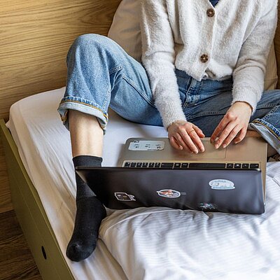 Man wokring on his laptop in the lobby of MEININGER Hotels