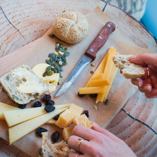 Queso y pan servidos como aperitivos con bebidas en hoteles MEININGER para una estancia perfecta