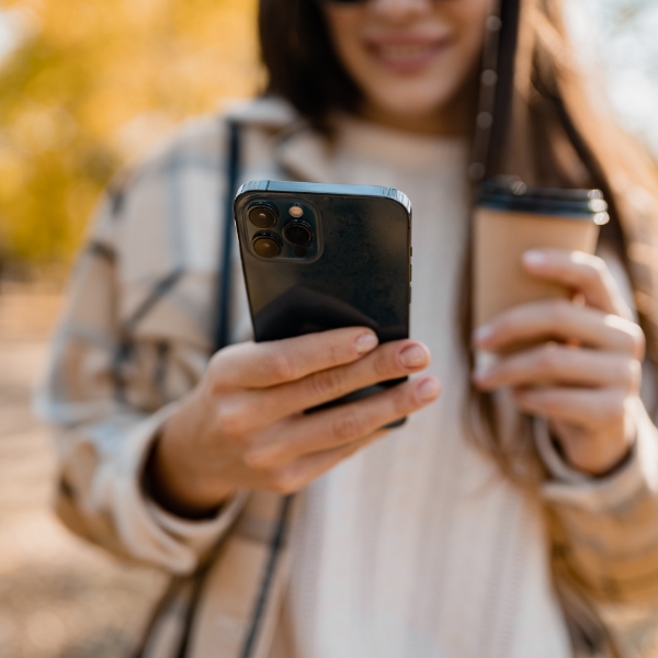 Huésped con café y teléfono, listo para personalizar su estancia en MEININGER Hotels.